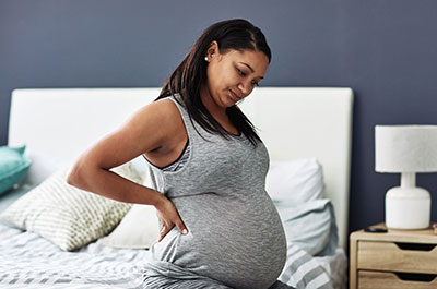 pregnant woman sitting on bed