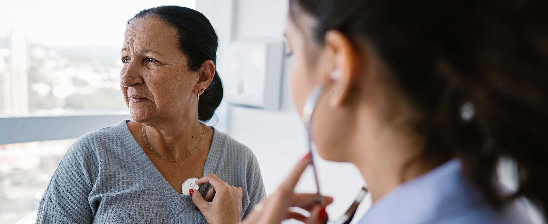 doctor listens to woman's heart