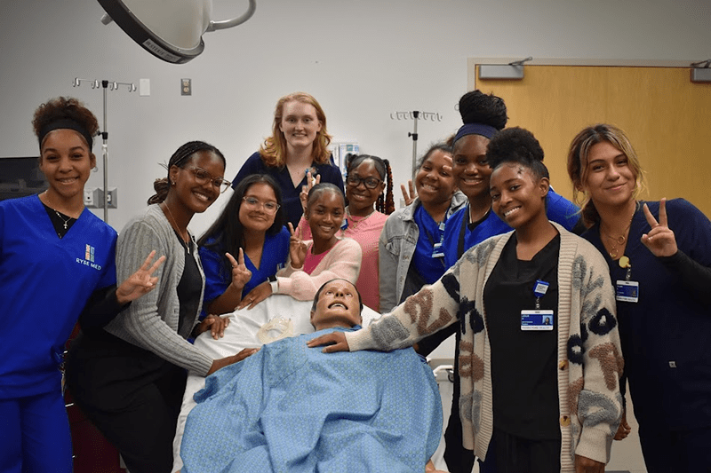Group of RYSE MED students standing with medical mannequin